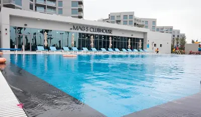 a large swimming pool in front of a building at Budget-friendly 2bd near EXPO with a huge pool in Dubai