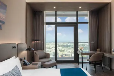 a hotel room with a bed and a chair and a desk at Paramount Hotel Midtown in Dubai
