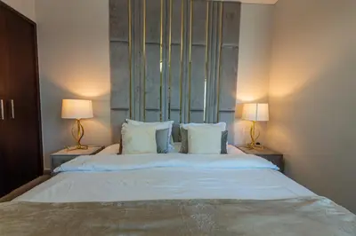 a bedroom with a large white bed with two lamps at Luxury 2BR Burj Khalifa Fountain View with Pool, Gym, and Near Dubai Mall in Dubai
