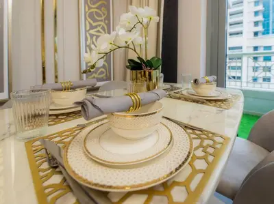 a dining room table with plates and bowls on it at Luxury 2BR Burj Khalifa Fountain View with Pool, Gym, and Near Dubai Mall in Dubai