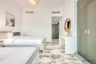 a bedroom with two beds and a mirror at Whimsical 2BR at Bella Rose Barsha South by Deluxe Holiday Homes in Dubai