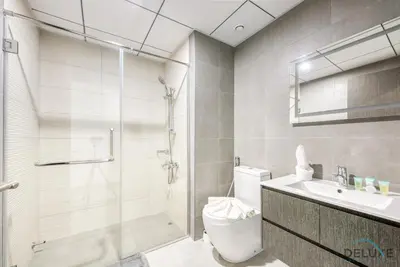 a bathroom with a shower and a toilet and a sink at Whimsical 2BR at Bella Rose Barsha South by Deluxe Holiday Homes in Dubai