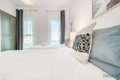 a bedroom with a white bed with two pillows on it at Whimsical 2BR at Bella Rose Barsha South by Deluxe Holiday Homes in Dubai
