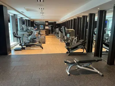 a gym with a row of treadmills and machines at Walk to Burj Khalifa from this 2BR with Skyline Balcony View in Dubai