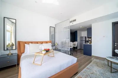 a bedroom with a bed with a table on it at Frank Porter - Yacht Bay in Dubai