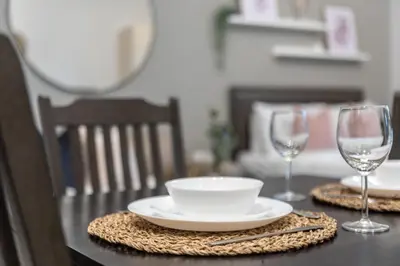 a table with a plate and two wine glasses at GuestReady Holiday Homes - On The Rocks in Dubai