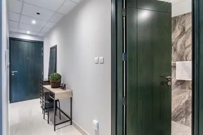 a bathroom with a green door and a table at GuestReady Holiday Homes - On The Rocks in Dubai