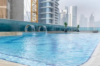 a large swimming pool in a city with tall buildings at GuestReady Holiday Homes - On The Rocks in Dubai