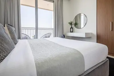 a large white bed in a room with a mirror at Frank Porter - 5242 EMAAR Tower in Dubai