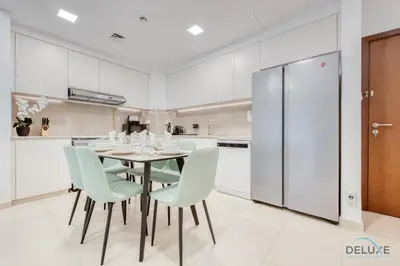 a kitchen with a dining room table and chairs at Exquisite 2BR at Zahra Breeze Dubailand by Deluxe Holiday Homes in Dubai