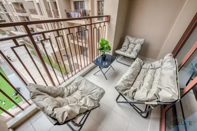 a balcony with two chairs and a table at Exquisite 2BR at Zahra Breeze Dubailand by Deluxe Holiday Homes in Dubai