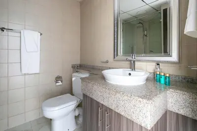 a bathroom with a sink and a toilet and a mirror at Frank Porter - The Point in Dubai