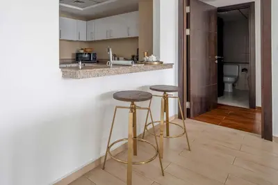 a kitchen with two bar stools and a counter at Frank Porter - The Point in Dubai