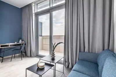a living room with a blue couch and a window at Silkhaus comfy DIFC studio with Burj Khalifa view in Dubai