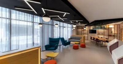 an office with chairs and a table and windows at Studio M Al Barsha Hotel by Millennium in Dubai