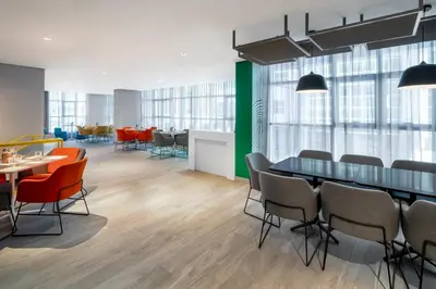 a conference room with tables and chairs and windows at Studio M Al Barsha Hotel by Millennium in Dubai