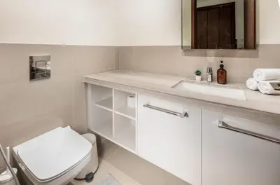 a white bathroom with a toilet and a sink at Spacious & Full of light 3BR+ kids Dubai Mall in Dubai