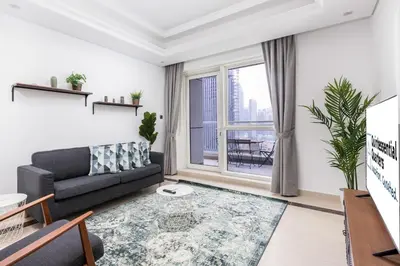 a living room with a couch and a large window at Lovely & Pristine 2BR + kids - 7min to Dubai Mall in Dubai
