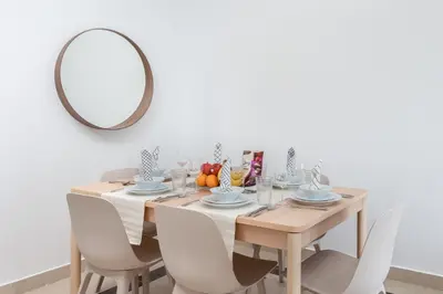 a dining room with a table with a mirror at Lovely & Pristine 2BR + kids - 7min to Dubai Mall in Dubai