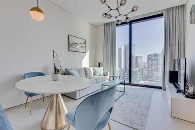 a living room with a table and a couch at Stylish 1BD apartment in Address Beach Residence in Dubai