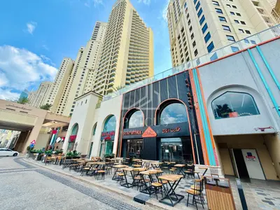 a street with tables and chairs in front of a building at Stylish 1BD apartment in Address Beach Residence in Dubai