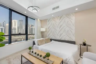 a bedroom with a bed and a large window at Modern 1BR with City View Rooftop Pool Access in Dubai