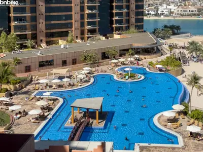 an overhead view of a pool at a resort at bnbme - Beachfront 1BR Palm Jumeirah Apt w Balcony Sea Views Pool & Beach Access in Dubai
