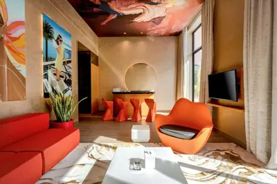 a living room with orange furniture and a tv at Voco Dubai Monaco, The Heart of Europe by IHG-Adult only in Dubai