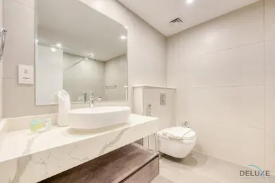 a white bathroom with a sink and a toilet at Spacious 3BR Apartment with Assistant Room in Sadaf 5 JBR by Deluxe Holiday Homes in Dubai