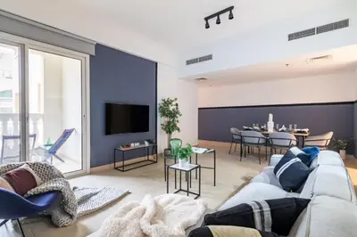 a living room with a couch and a tv at The Smart Concierge - Plaza residence in Dubai