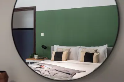 a bedroom with a bed with a green wall at The Smart Concierge - Plaza residence in Dubai