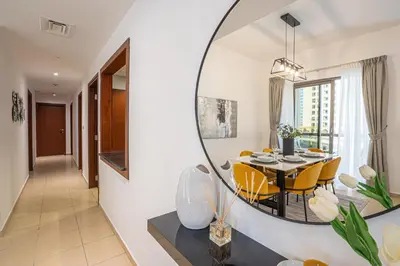 a dining room with a table and a mirror at HiGuests - Stylish Apartment in JBR Steps From the Beach in Dubai