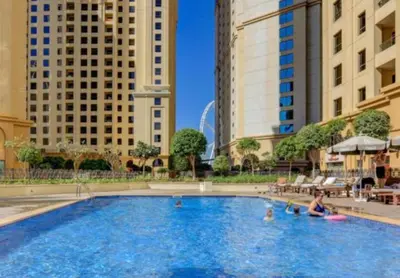 a woman sitting in a swimming pool in a city at HiGuests - Stylish Apartment in JBR Steps From the Beach in Dubai