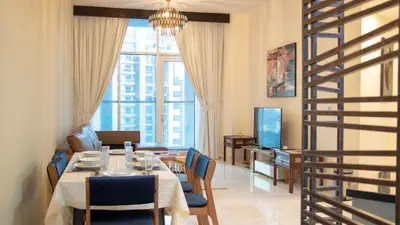 a dining room with a table and chairs and a living room at AWS Holiday Homes - Luxury Living besides Canal in Dubai
