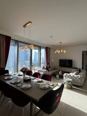 a living room with a table with chairs and a couch at Burj Khalifa view, 3 Bedroom Apartment in Boulevard Point, Connected to Dubai Mall in Dubai
