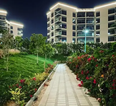 a walkway in front of a building with flowers at Elegant and comfortably furnished 2BRH apartment in a quiet area! in Dubai