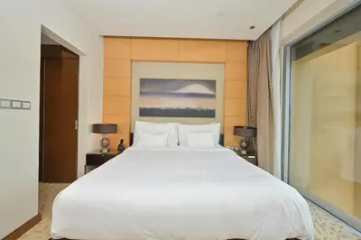 a large white bed in a room with a window at Emaar Fashion Avenue - Formerly Address Dubai Mall Residence in Dubai