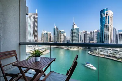 a balcony with a table and chairs and a river at GuestReady - Marina View | Fairfield Tower in Dubai