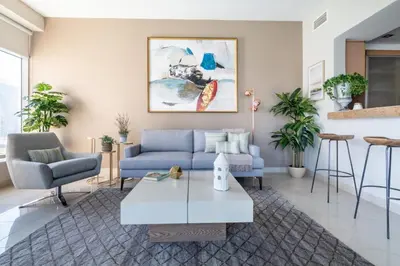 a living room with a blue couch and a table at GuestReady - Marina View | Fairfield Tower in Dubai