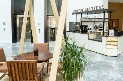 a cafe with a table and chairs and a counter at Al Khoory Courtyard Hotel in Dubai