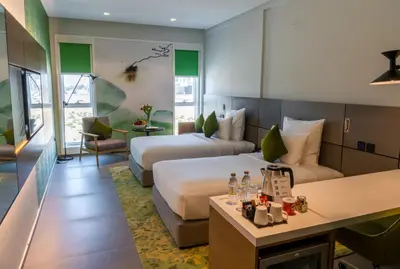 a hotel room with two beds and a desk at Al Khoory Courtyard Hotel in Dubai