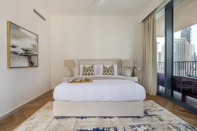 a white bedroom with a large bed and a large window at Frank Porter - BLVD Heights T1 in Dubai