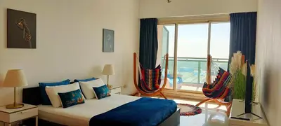 a bedroom with a bed and a large window at Nice 2 bedroom apartment-minimum 5 night in Dubai