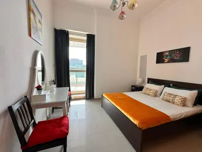 a bedroom with a bed and a desk and a window at Nice 2 bedroom apartment-minimum 5 night in Dubai