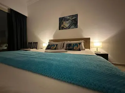 a bedroom with a large bed with a blue blanket at Nice 2 bedroom apartment-minimum 5 night in Dubai