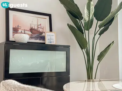 a tv with a glass table and a plant at HiGuests - Exceptional Apt with Furnished Terrace By the Sea in Dubai