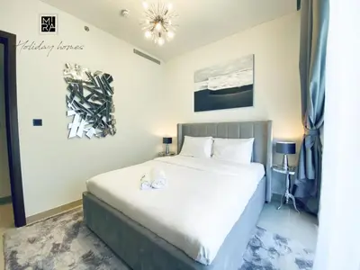 a bedroom with a large white bed in a room at Mira Holiday Homes - Newly Furnished 1 bedroom in Creek Vista Tower B Sobha Hartland in Dubai