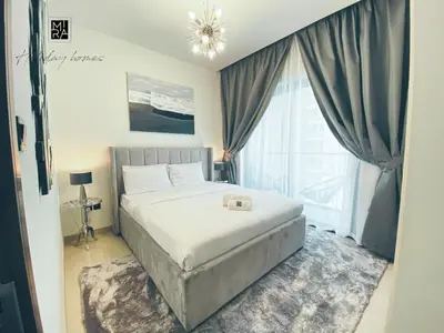 a bedroom with a bed and a large window at Mira Holiday Homes - Newly Furnished 1 bedroom in Creek Vista Tower B Sobha Hartland in Dubai