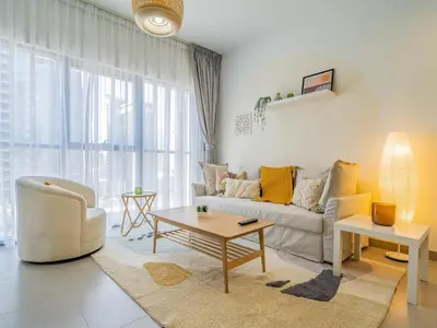 a living room with a couch and a table at Charming Tropical Apartment Minutes To Dubai Mall in Dubai