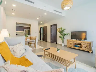 a living room with a couch and a table at Charming Tropical Apartment Minutes To Dubai Mall in Dubai